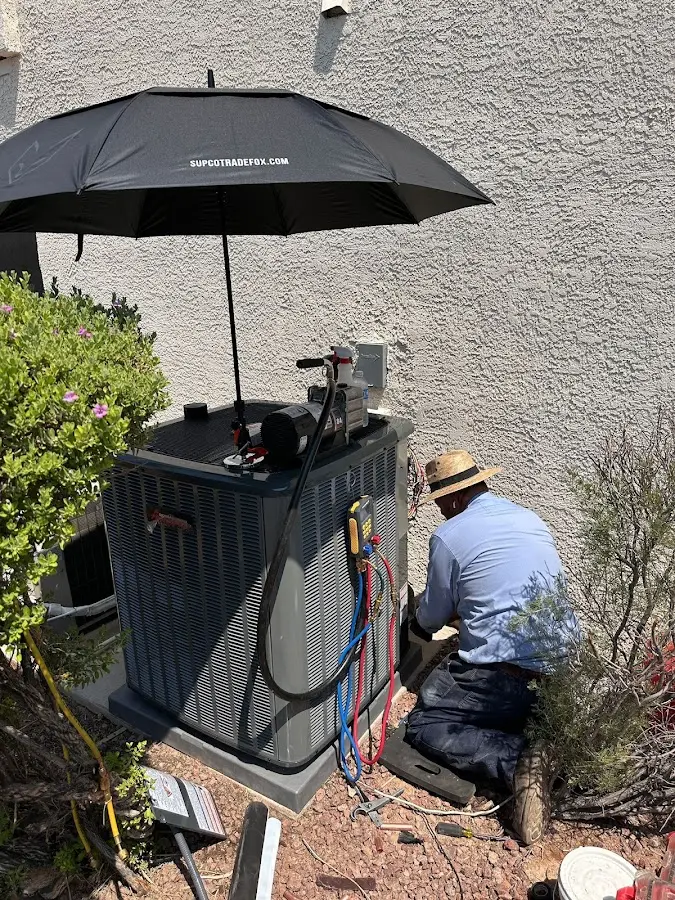 HVAC technician performing outdoor AC maintenance in Cottage Grove